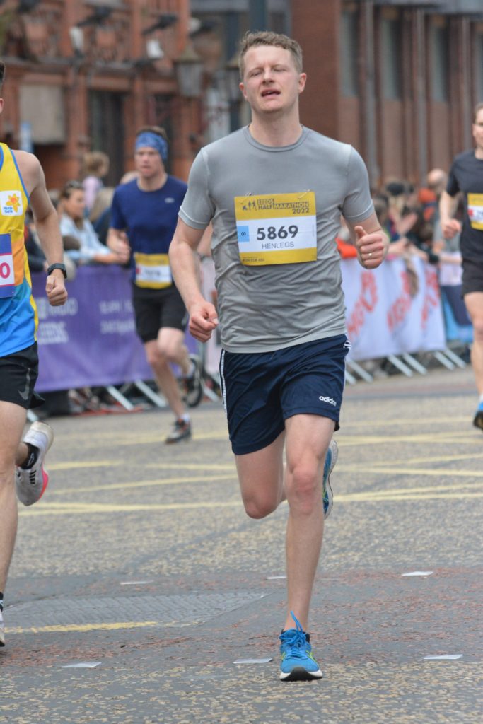 An exhausted man running in a road race.