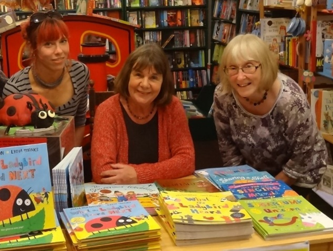 Julia Donaldson (centre) and two other women at a table in a children's bookshop.