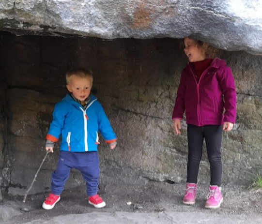 Son and daughter of author playing under a rock ledge